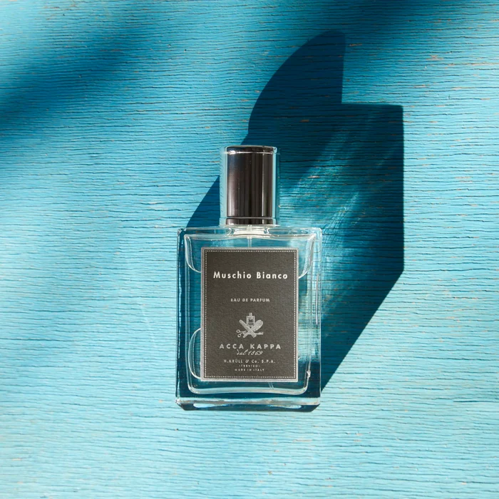 Acca Kappa Muschio Bianco Eau de Parfum på blåmalt treoverflate med tydelig skygge