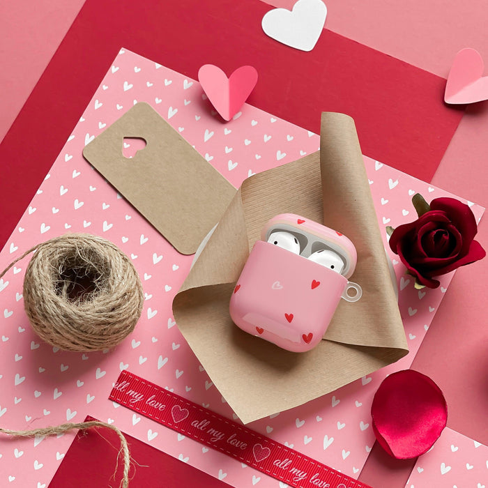 Coconut Lane AirPods case with cute heart pattern, shown on brown paper with roses, twine, and heart-themed gift wrap.