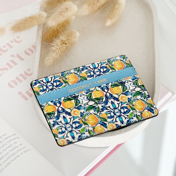 Yellow Amalfi Lemon card holder by Coconut Lane on a white tray beside dried flowers.