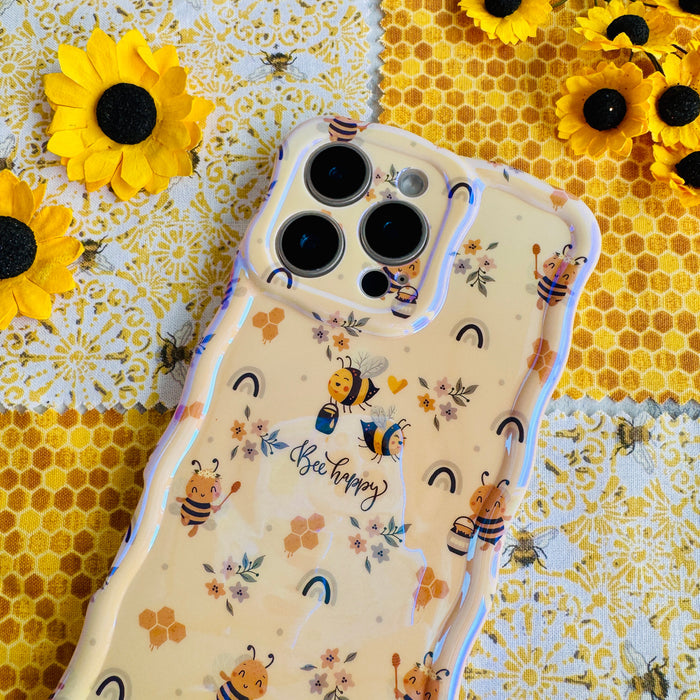 A phone case with a wavy edge design featuring floral prints and bees, held in a person's hand.