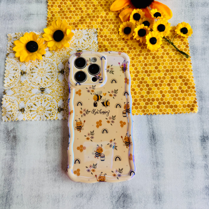 A phone case with a wavy edge design featuring floral prints and bees, held in a person's hand.