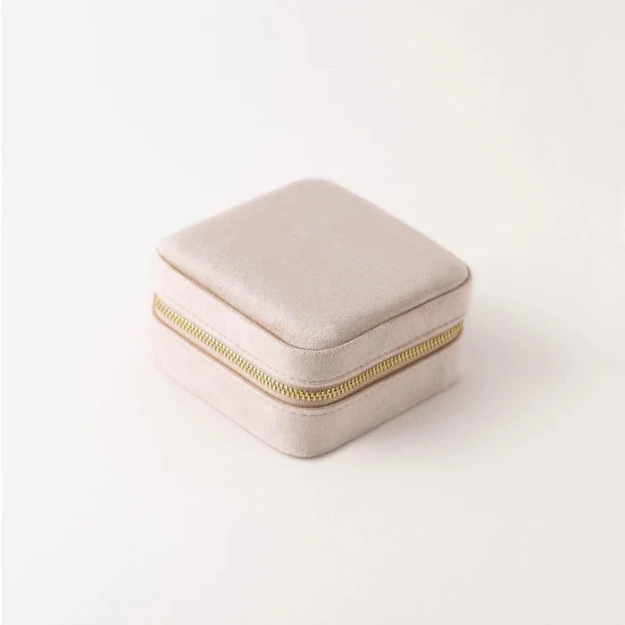 Beige jewelry box with a gold zipper on a white background