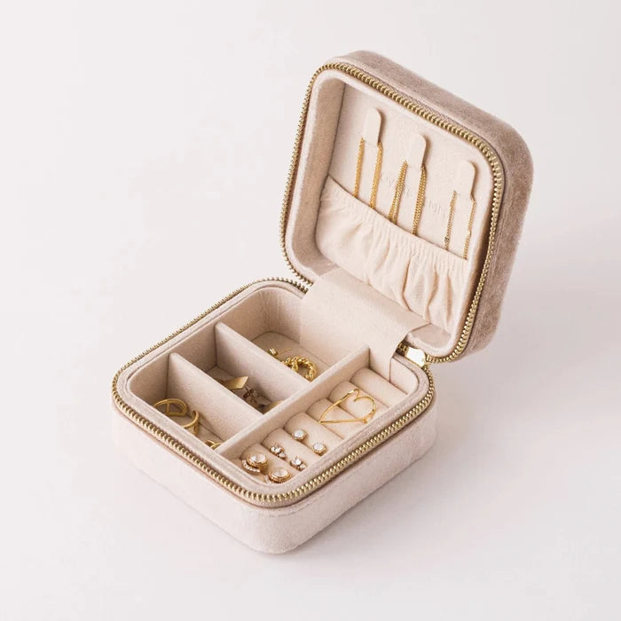Beige jewelry box with gold earrings on a white background
