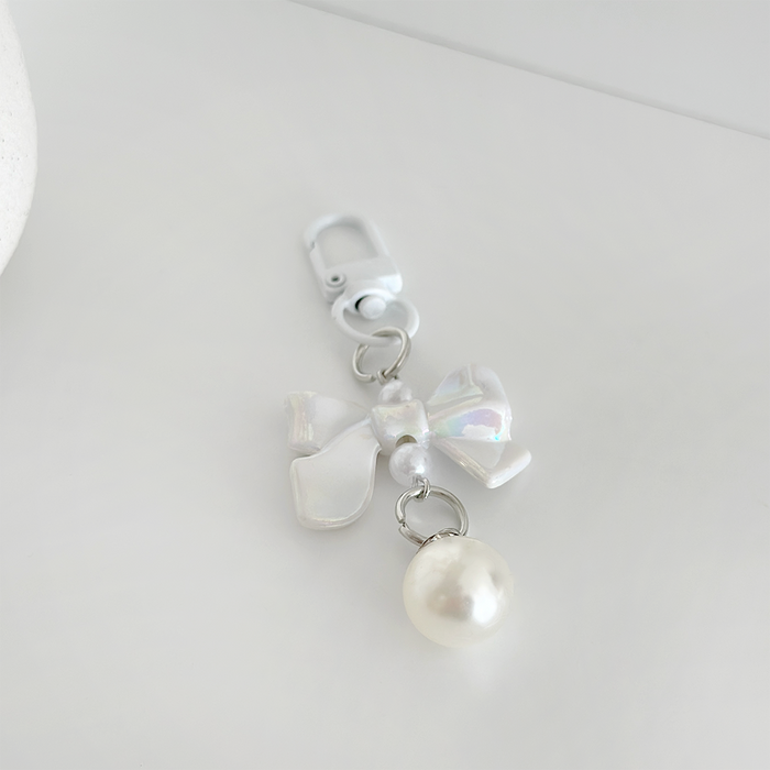 Iridescent Coquette Bow Keyring by Coconut Lane with a pearl and metal clasp on a white background.