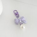 Lilac Coconut Lane keyring with a purple bow and pearl bead displayed on a white surface.