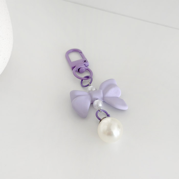 Lilac Coconut Lane keyring with a purple bow and pearl bead displayed on a white surface.