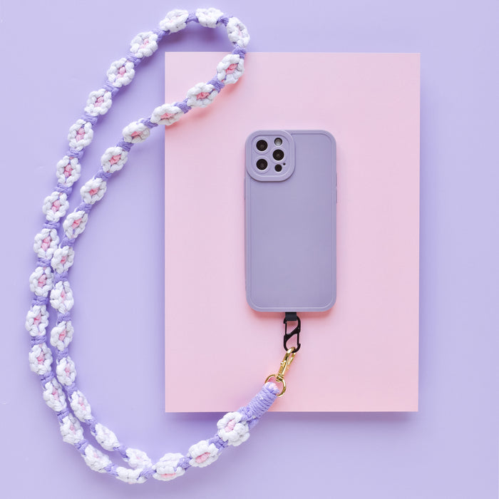Lilac crochet flower phone lanyard bundle on pink paper with a purple background.