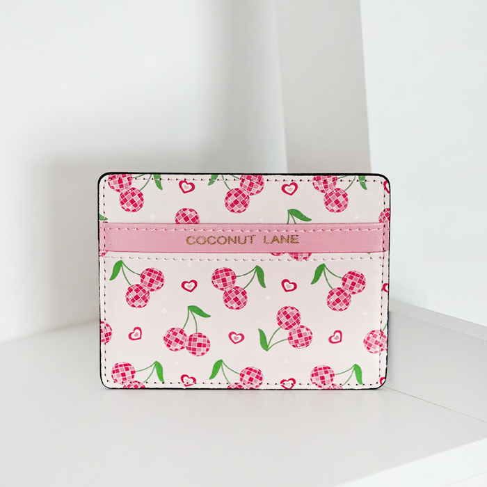 Pink and white card holder with cherry and heart patterns, finished with gold Coconut Lane branding on top.