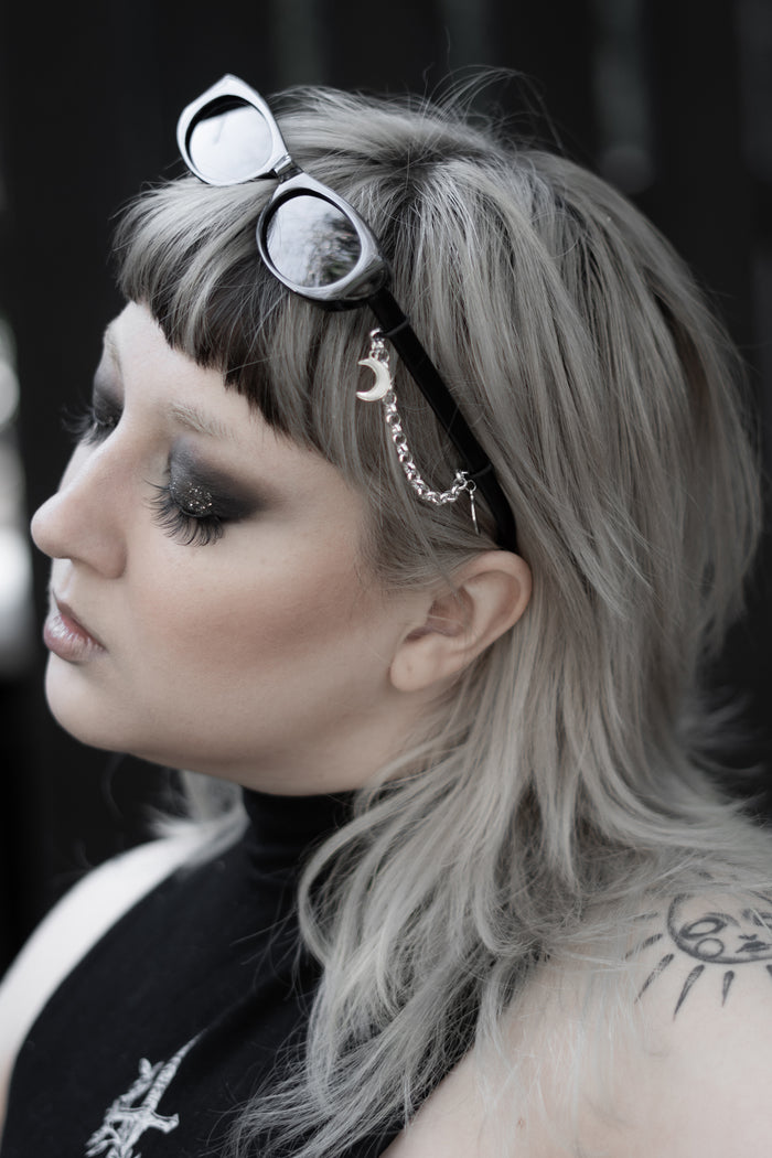 Model wearing False Idol Sunglasses by The Pretty Cult, black tinted rectangular shades
