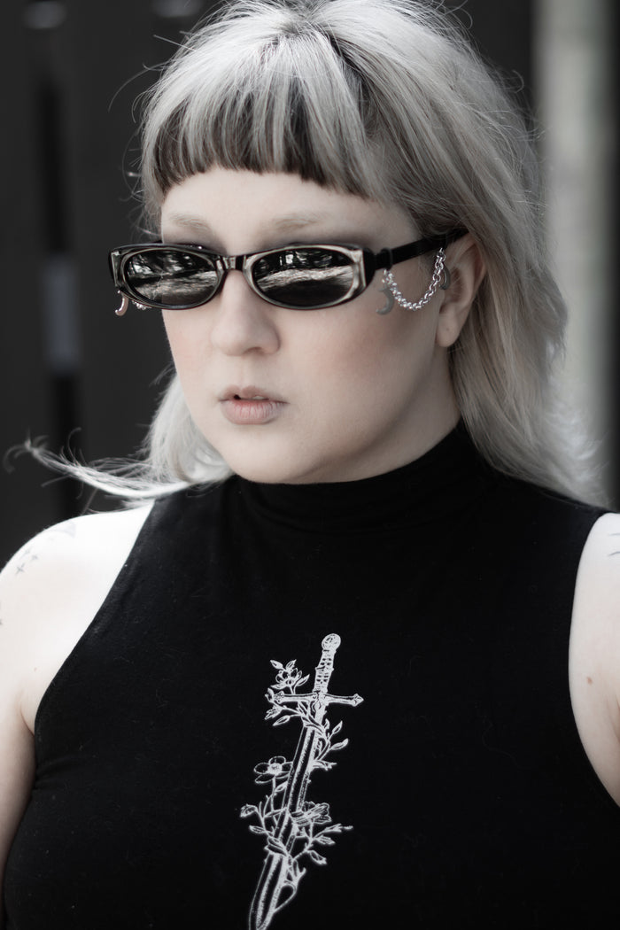 Model styled in the False Idol Sunglasses, sleek black frame with tinted lenses
