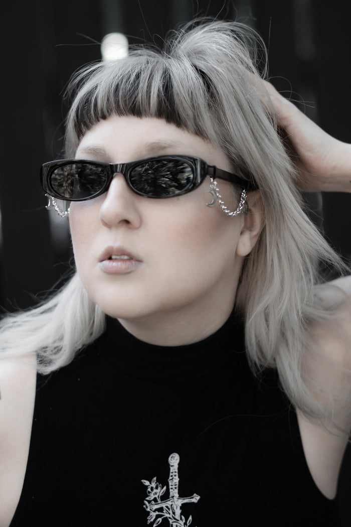 Model styled in the False Idol Sunglasses, sleek black frame with tinted lenses