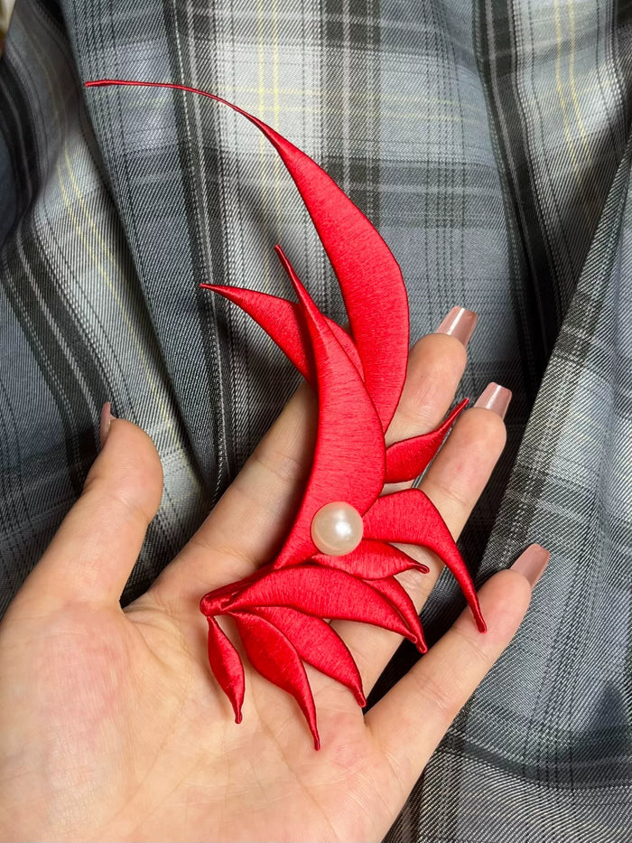 A red handmade Chanhua - style Zhang He hair accessory with a pearl in the center on a wooden box-2
