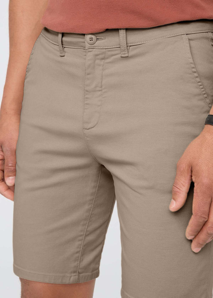 Sandstone shorts with button closure and front pockets, worn with a rust-colored shirt.
