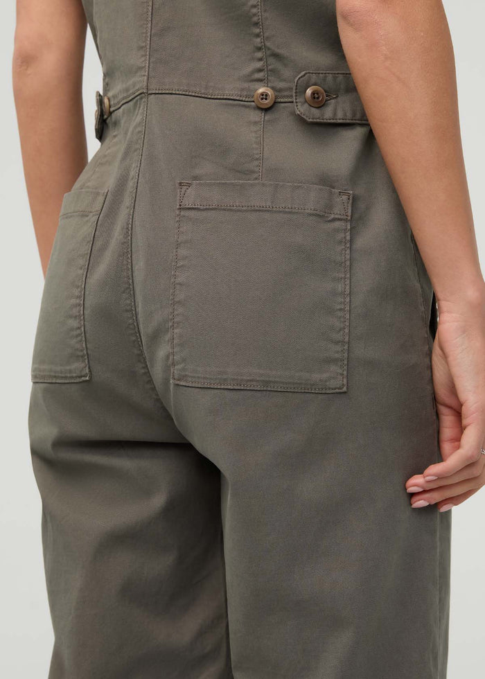 Thyme-colored boiler suit with button-front closure, belt, and cargo pockets shown on model from waist down.