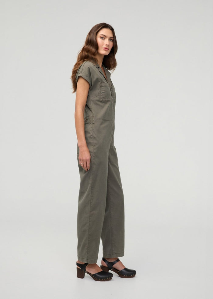 Thyme boiler suit with short sleeves, front button closure, and patch pockets, worn with black clogs.