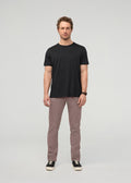 Man wearing black short-sleeve t-shirt and hazy mauve slim straight chino pants with black sneakers.