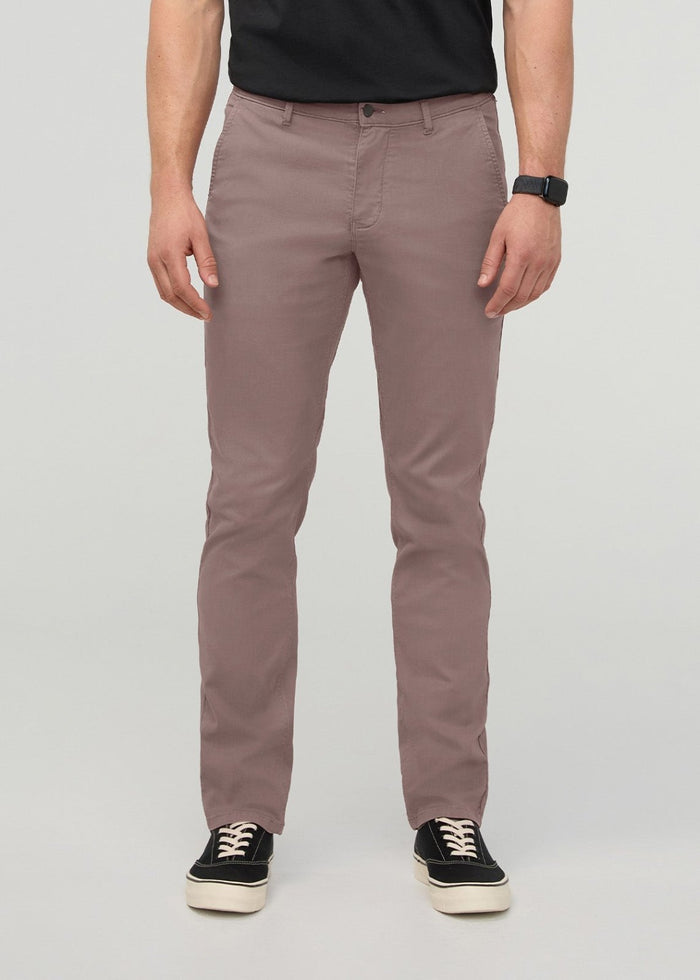Man wearing hazy mauve slim straight chino pants with black t-shirt and black sneakers.