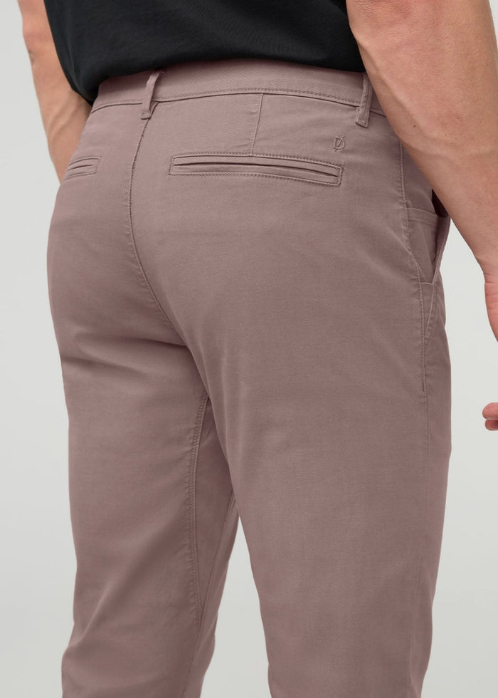 Hazy mauve chino pants with straight leg fit, back pocket detail visible, worn with black shirt.