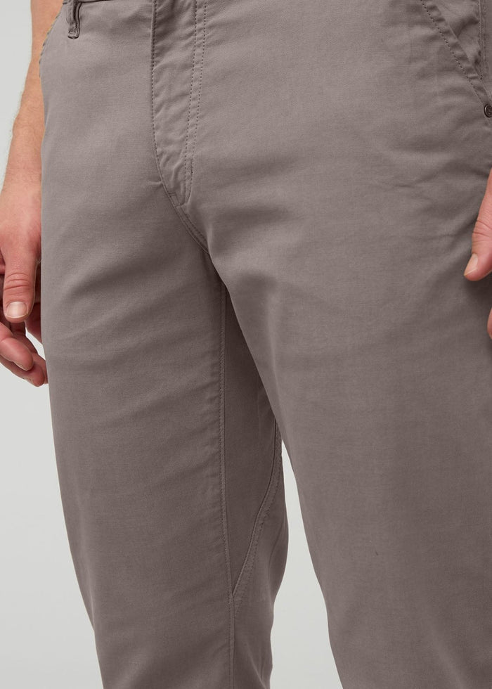 Stone-colored casual pants with flat front and visible center seam on male model.
