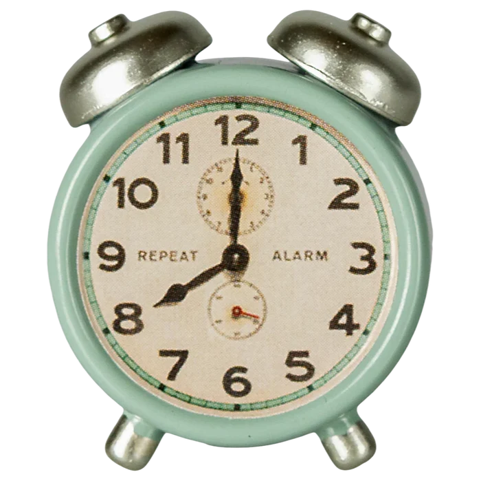 Vintage-style alarm clock with a light green casing on a white background