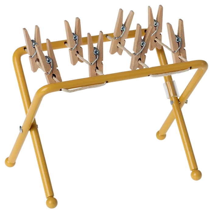 Yellow clothespin rack with wooden pegs on a white background