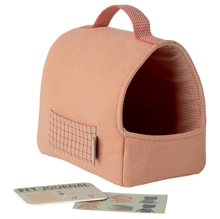 Coral pet carrier with a pet journal and cards on a white background