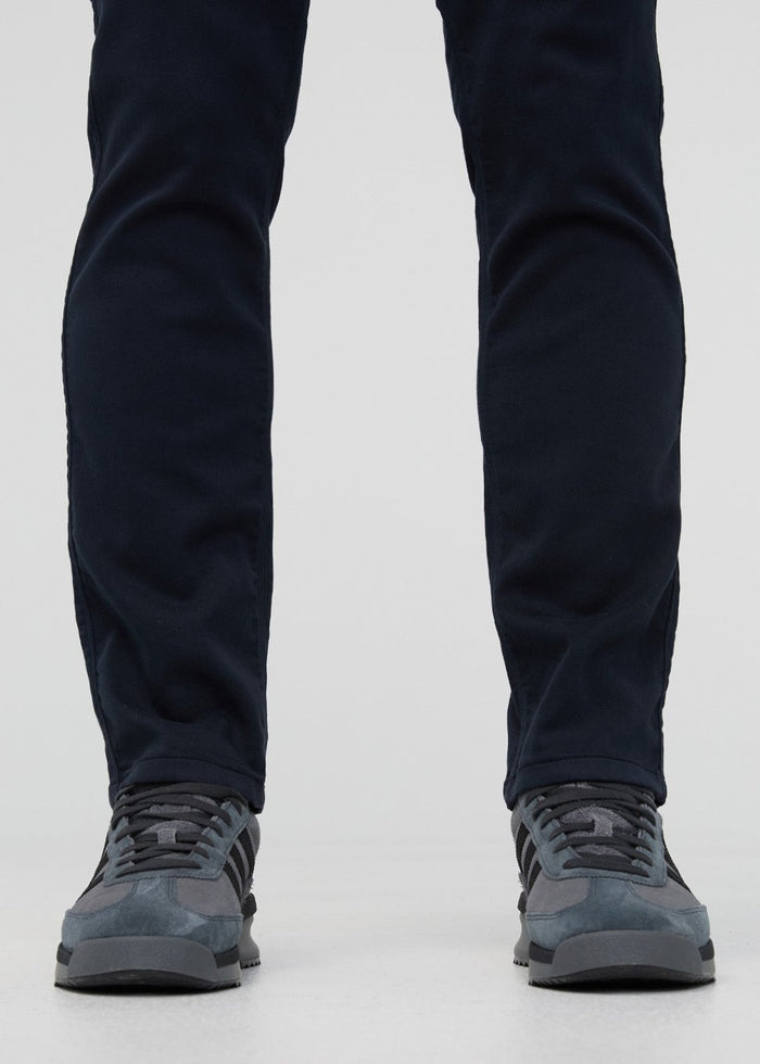 Navy slim straight pants with straight leg opening worn with gray lace-up hiking boots.