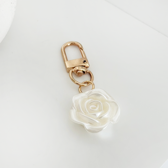 Gold keyring with a clasp and a white pearl flower charm.