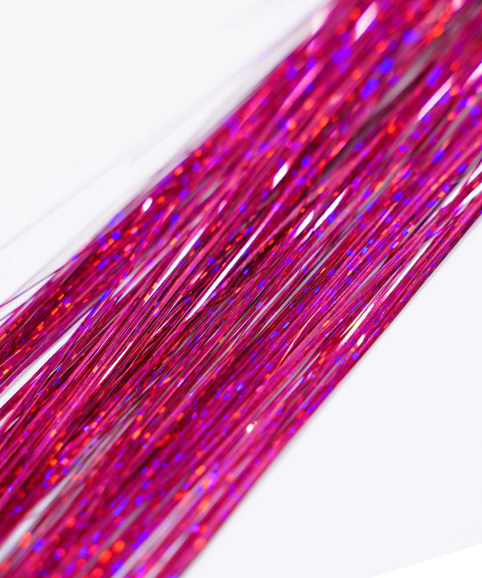 Close-up of Perfect Locks' Perfect Hair Tinsel in "Night Out" with shiny pink and purple strands sparkling on a white background.#color_hot-pink