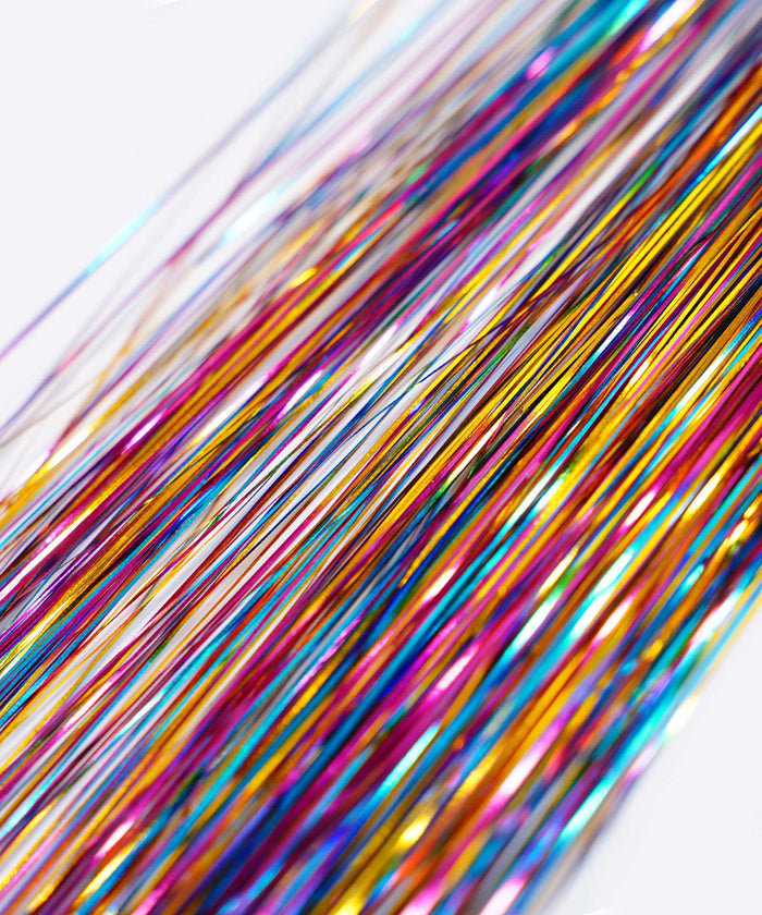 Close-up of Perfect Hair Tinsel by Perfect Locks in Gold Glitz mingled with hair extensions; shiny threads add vibrant sparkle.#color_night-out
