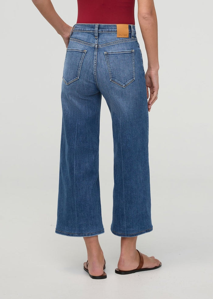 High-rise blue denim crop with wide leg silhouette, shown from back view with orange waistband label.