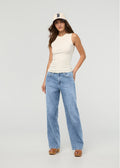 Light stone wash high-rise straight denim jeans on model wearing cream sleeveless tank top.