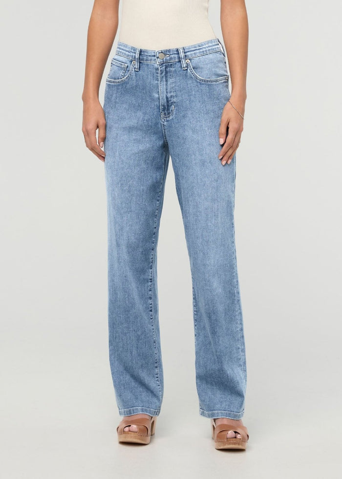 Light blue high-rise straight denim jeans with five-pocket styling on a model wearing a cream top and tan platform sandals.