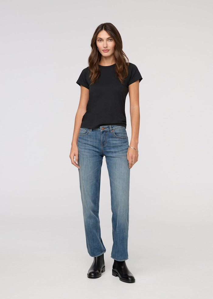 Woman wearing a black t-shirt and blue jeans on a white background