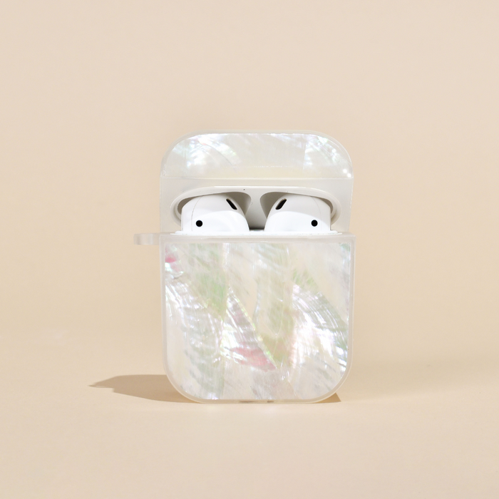 White wireless earbuds in a white natural shell AirPods case on a beige background.