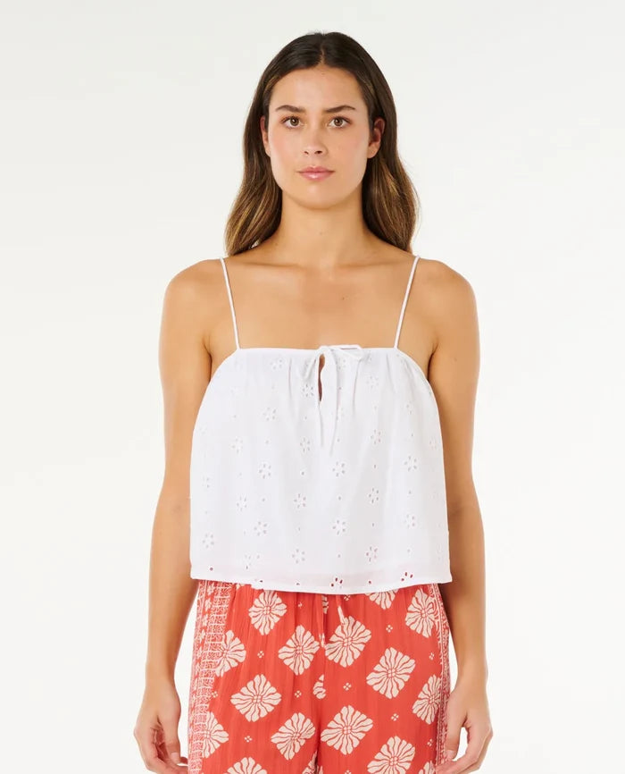 Woman wearing a white top and red floral pants on a white background