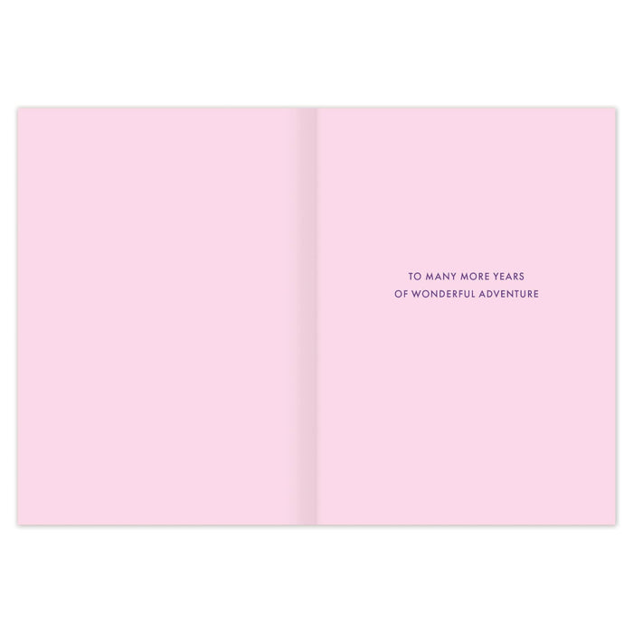 Open pink card with text 'To many more years of wonderful adventure' on a white background