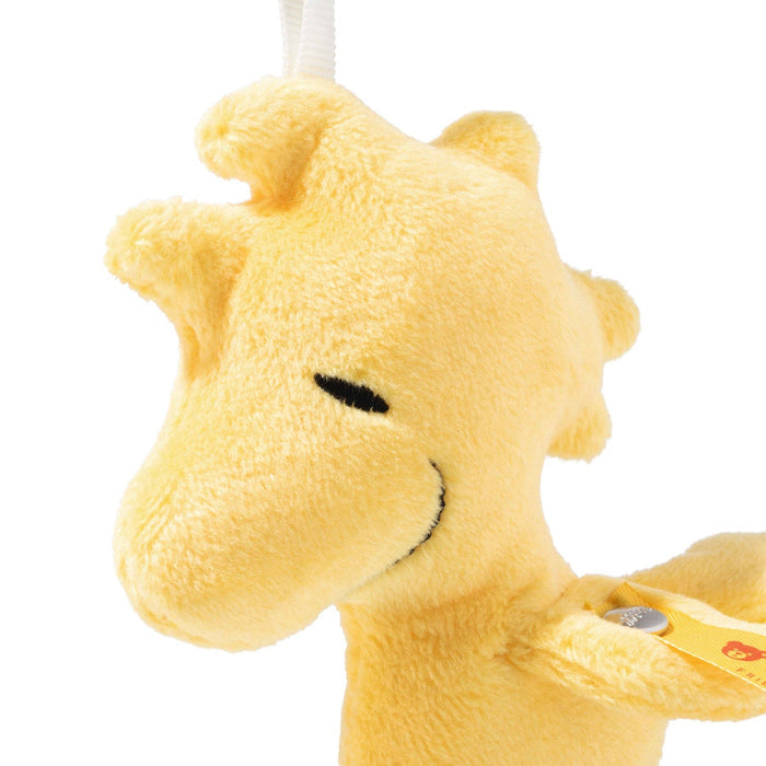Close-up of a yellow plush woodstock toy with a white background