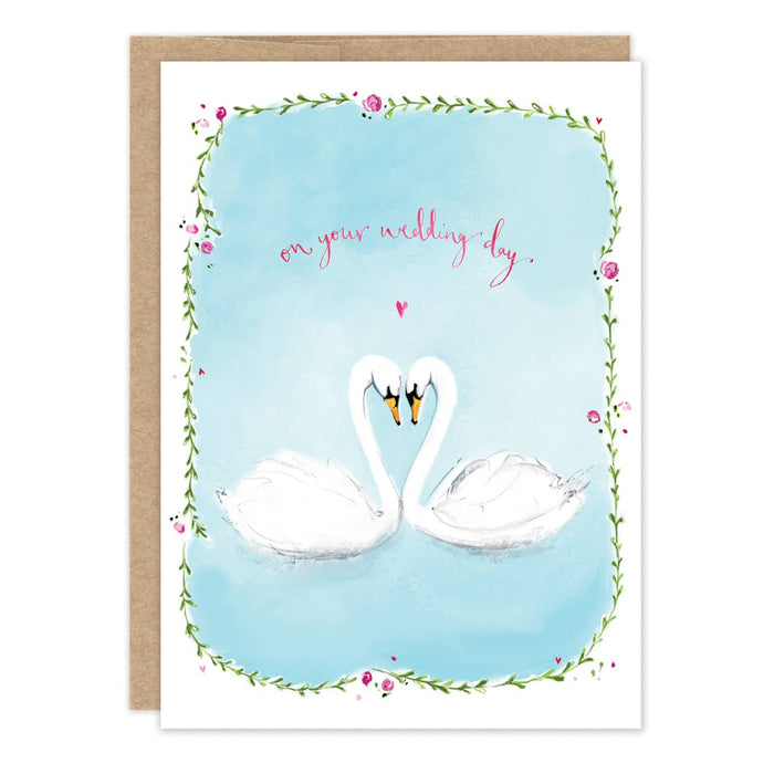 Greeting card with two swans facing each other on a blue background, surrounded by floral elements and text 'on your wedding day'.
