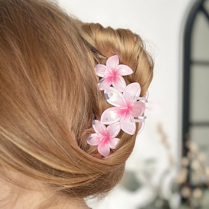 Light brown hair in an updo secured with a pink triple flower claw clip from Coconut Lane.