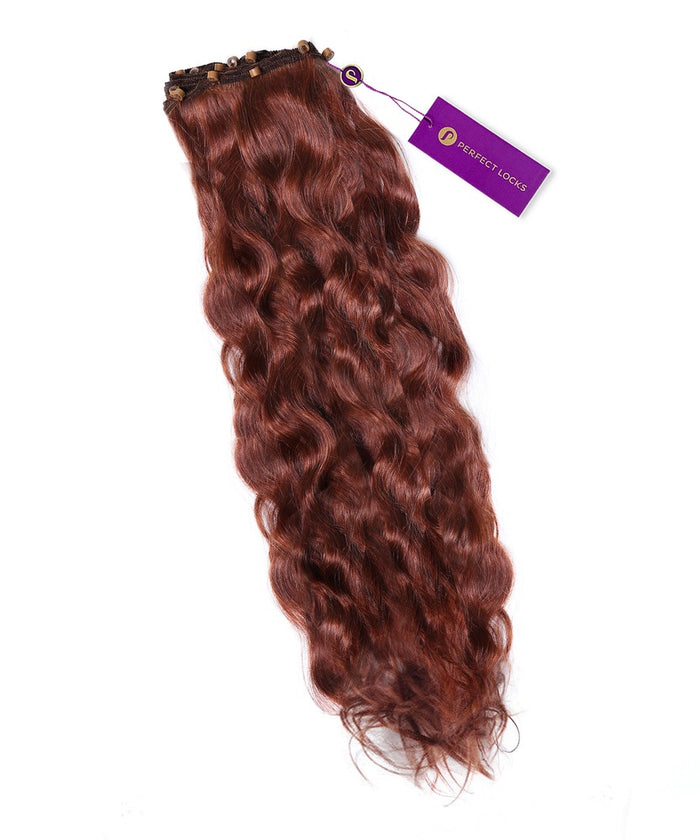 A bundle of wavy, honey blonde  Wavy Beaded Weft Rows by Perfect Locks with natural shine, waves, and a purple tag on top.#color_dark-auburn-(33)